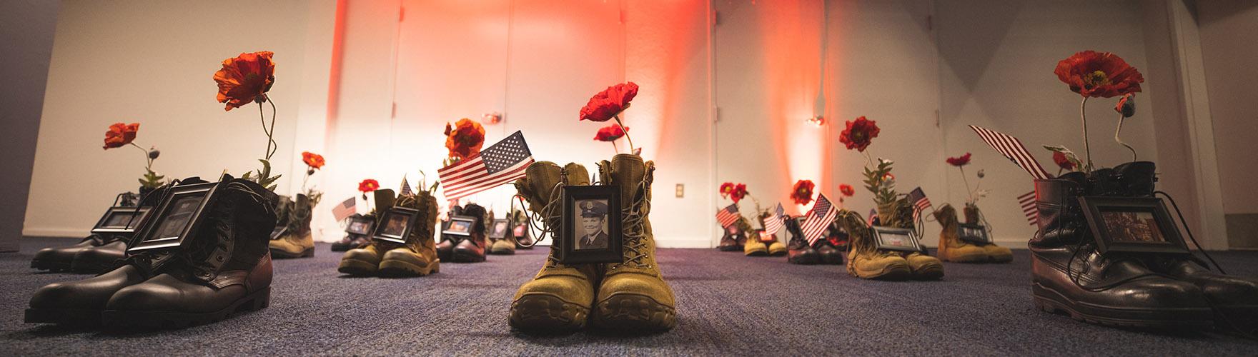 A Memorial Day display of boots, photos, and flowers honors those lost.
