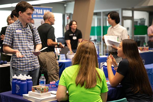 Student interacting with employers at a career event