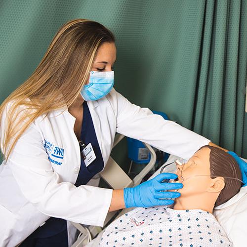 护理专业的学生正在练习给假病人输氧